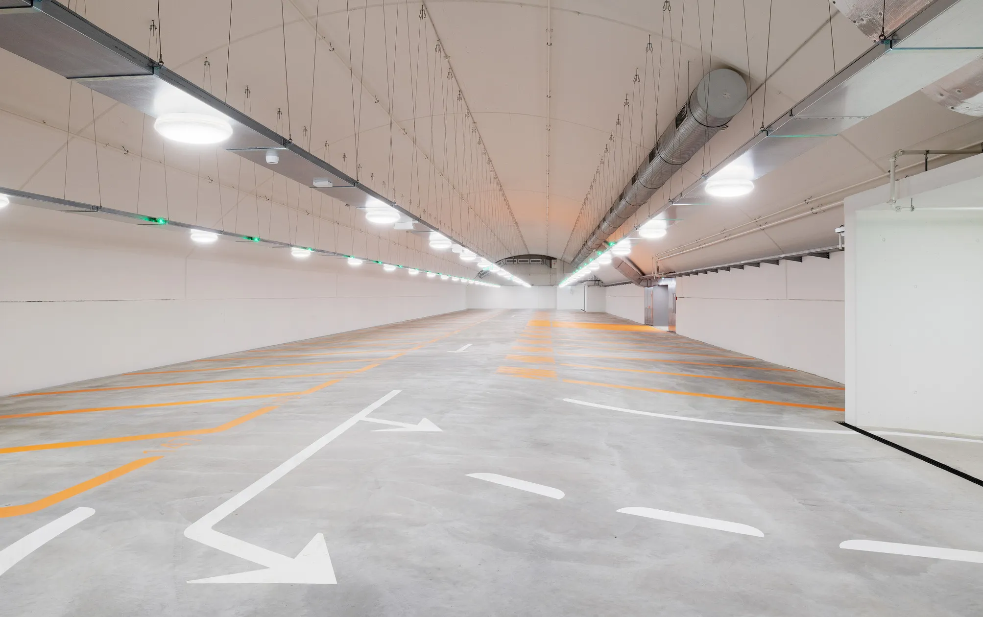 Hell gestrichene Fahrbahn im Schlossbergparking Thun mit weissen Wänden und Bodenmarkierungen