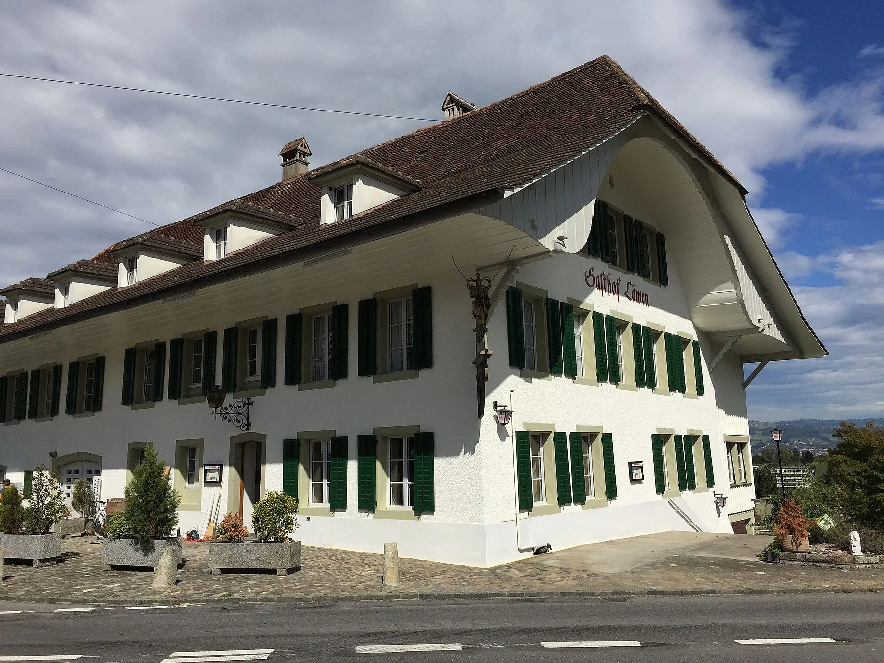Gasthof Löwen in Thierachern mit weisser Fassade und grünen Fensterläden