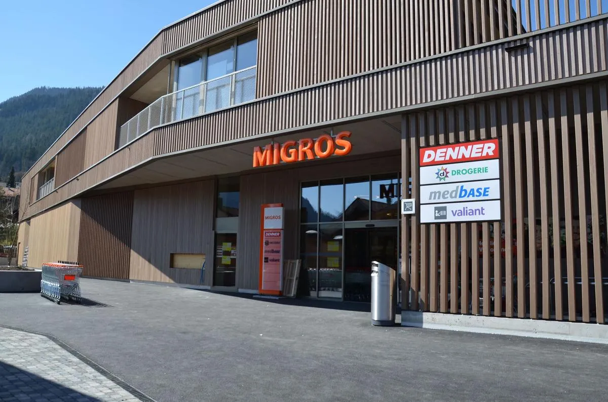 Eingang der Migros Zweisimmen mit Fassade aus Holzlamellen