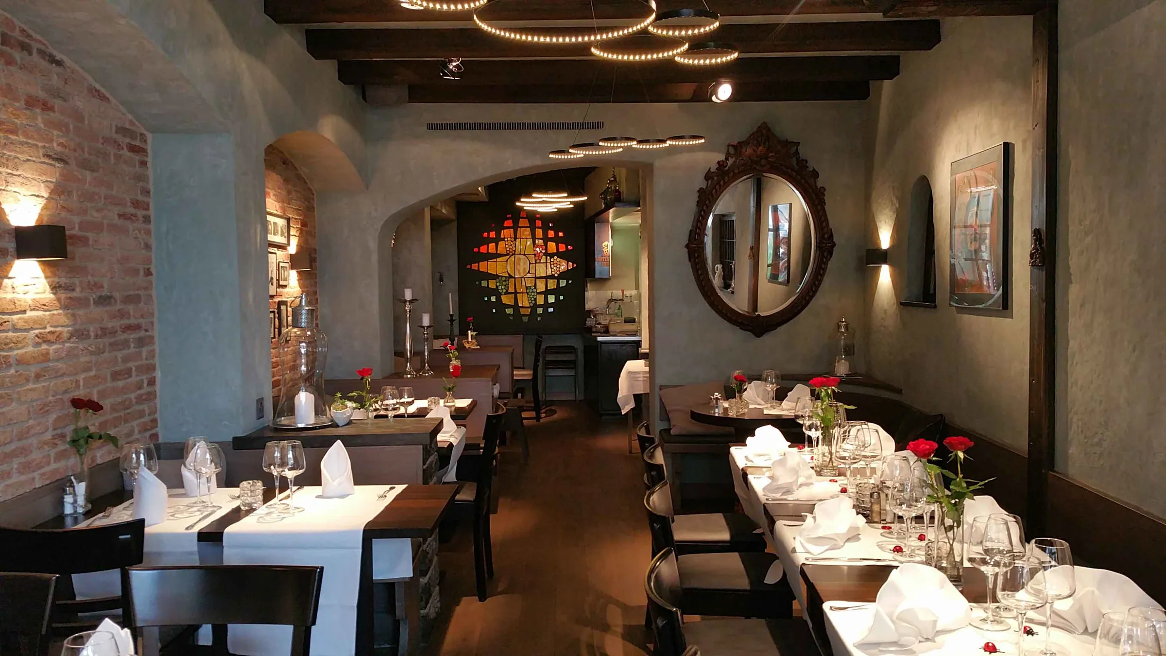 Restaurant Steinbock Thun mit graugrüner Lasurtechnik an Wänden und Gewölben, gedeckten Tischen und Holzbalkendecke